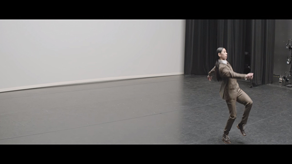 Screenshot, "Ingenue." Takase in the middle of her exaggerated walk.