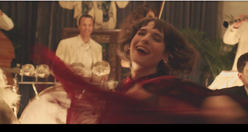 Gittel (Hari Nef) whips her velvet cape in a flashback to 1933 Berlin. Screenshot taken by the author.